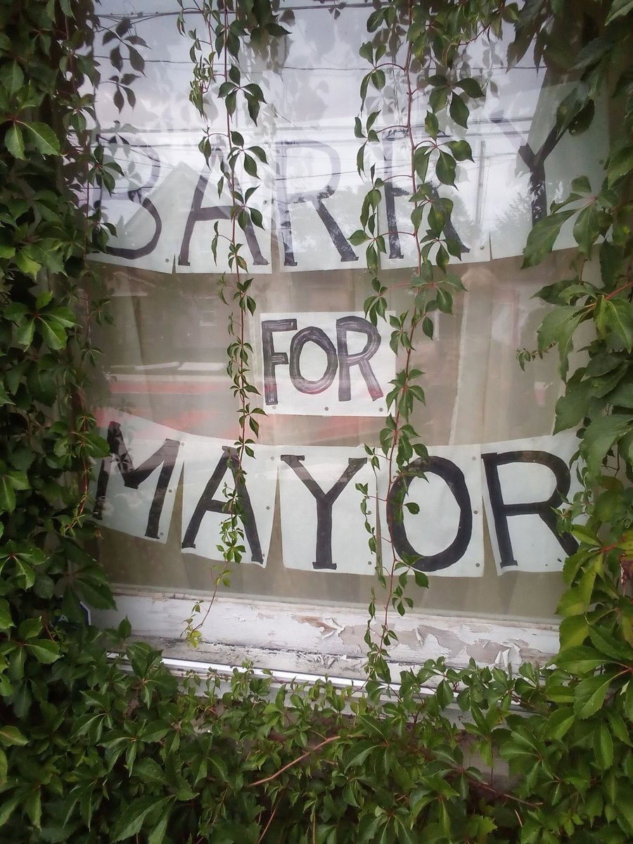 The hand-lettered "Barry for Mayor" campaign sign in a window, framed by ivy